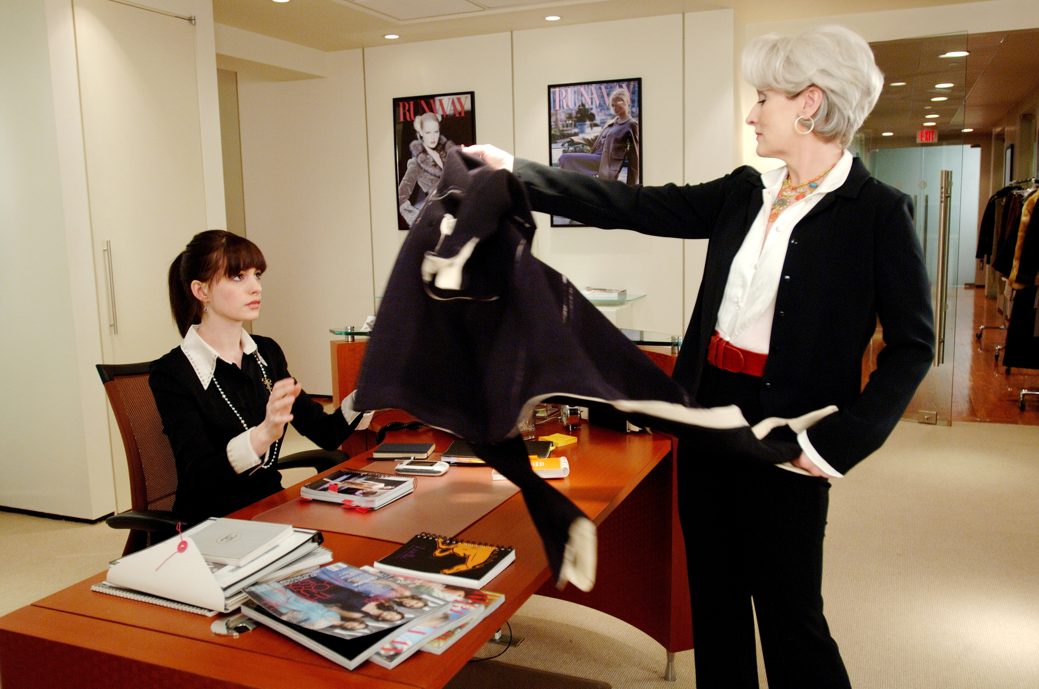 Anne Hathaway being handed a jacket by Meryl Streep in 'Devil Wears Prada'